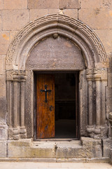 Fototapeta na wymiar The entrance door to the ancient temple with a cross on the door Goshavank , Armenia