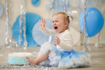 Cheerful children's birthday baby girl on a background of blue air-blasting and blue papyrus...
