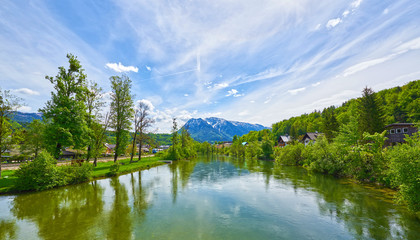 Scenic picture-postcard landscape with lake Traun, dorf, forest and mountains. Upper Austria.