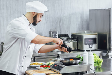 The chef prepares fresh salmon fish, smorgu trout, sprinkling salt with the ingredients. Frost freezing in the air. Preparing to cook fish food. Salmon steak.