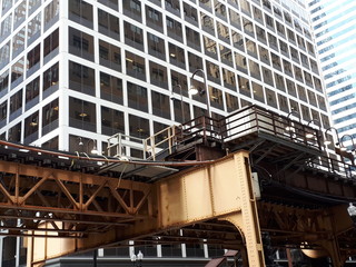 Industry view with iron & steel architecture. Old brown metal structure. Urban design, engineering machinery near high tall business building. Office skyscrapers : stairs, concrete, bridge, factory. 