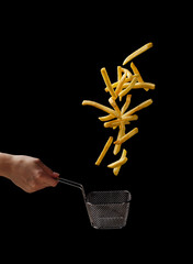 French fries - fried potatoes flying out of basket, fly fastfood
