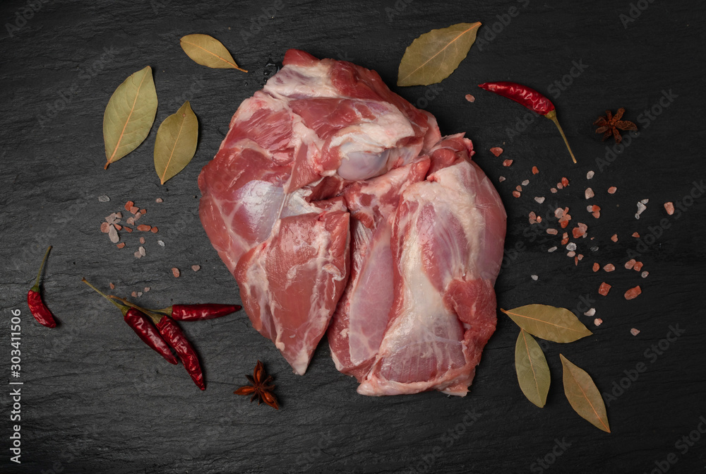 Wall mural fresh raw beef steak on black stone background