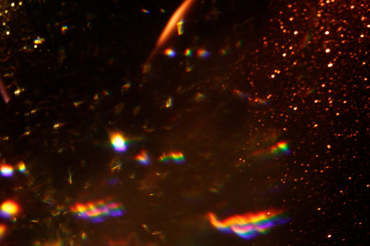 Easy to add lens flare effects for overlay designs or screen blending mode to make high-quality images. Abstract sun burst, digital flare, iridescent glare over black background. Defocused dark bokeh.