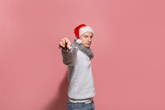 Happy man in a white sweater, Santa hat and trumpery is excited to celebrate Christmas and New Year.