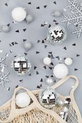 Xmas holiday decorative white and silver balls and snowflakes flowing from eco-friendly shopping mesh bag