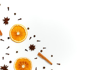 Christmas composition made of dried oranges, cinnamon, black peppers, star anice and clove on white background. Top view, copy space. Set of spices for mulled wine.