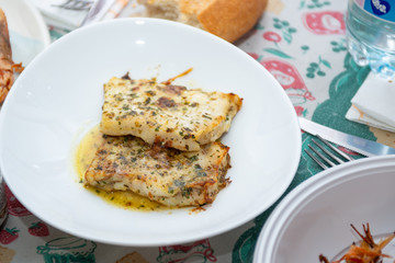 fish after cooking and prawns baked in background on a table