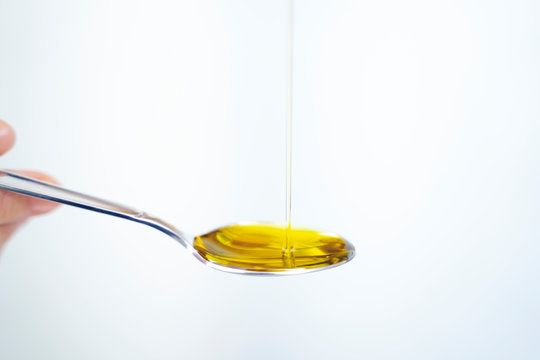 olive oil and spoon isolated on a white background