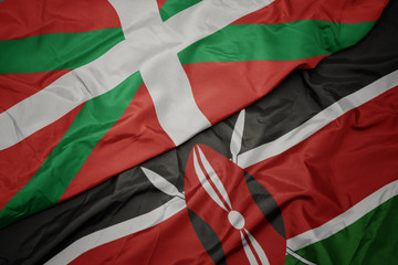 waving colorful flag of kenya and national flag of basque country.