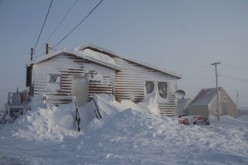 Building covered in snow following a snow storm, located in Arviat, Nunavut Canada