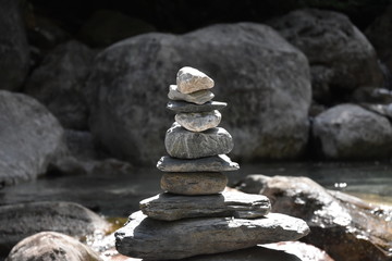 Fototapeta na wymiar stack of stones in small river with rocks