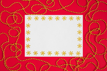 Christmas mockup with snowflakes and gold garland on red background. Happy new year. Space for text. Winter concept.