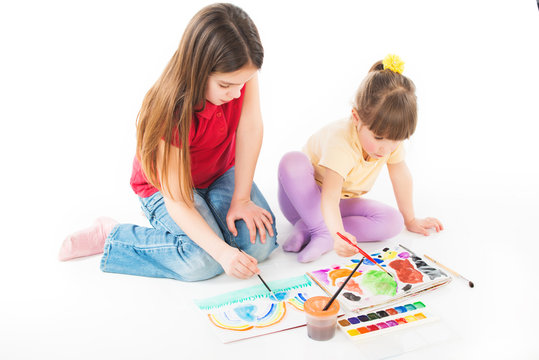 Children enthusiastically paint with watercolors