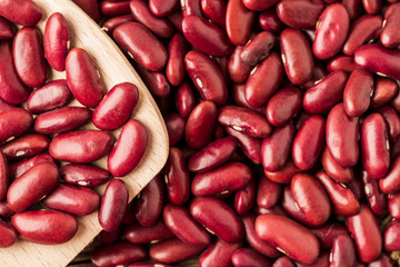 Red kidney bean close up rith spoon on wooden desk