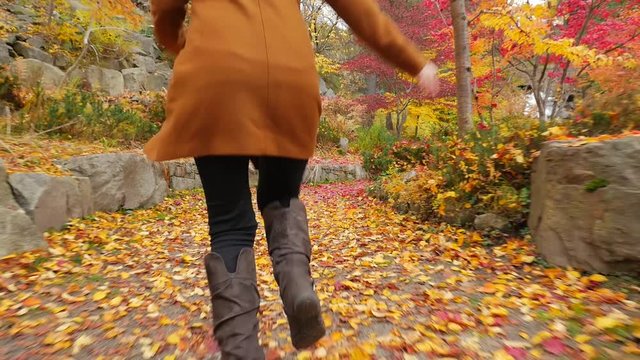 Young Female In The Fall Running On Path With Colorful Leaves