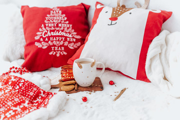 Christmas background. Holiday still life, coffee cup with cookies on bed. Christmas morning