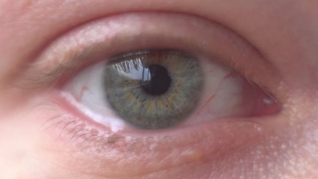 Macro close-up on crying human eye, tears streaming down