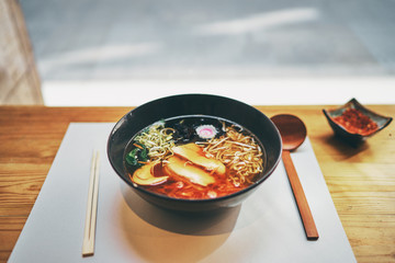 Delicious ramen noodle soup on wooden table.