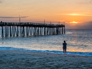 Person photographs sunrise over the fishing pier at Outer Banks North Carolina