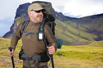 Fototapeta na wymiar happy tourist man on the background of the mountain. Beautiful mountain landscape in Iceland