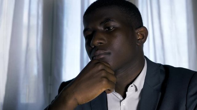 Pensive confident busy young black business man working with laptop in office