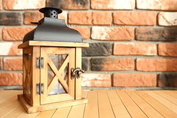Fototapeta na wymiar Home decor - wooden lantern for a tealight candle on the background of a brick wall
