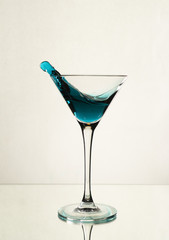 A splash of blue alcohol in a Martini glass