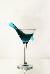 A splash of blue alcohol in a Martini glass