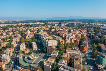 Fototapeta premium Aerial view of Rome Italy residential areas with houses, flight on drone above city buildings in sunny day.