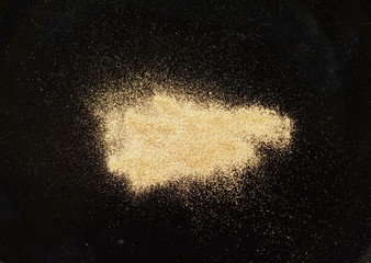 gold glitter powder on black background