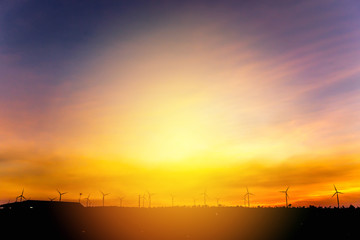 Wind turbine generator farm with sunset sky background