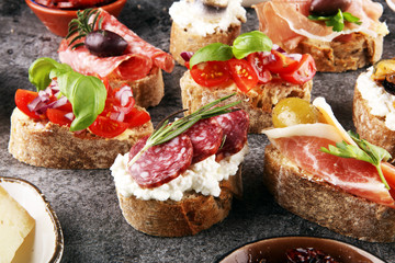 Appetizers table with italian antipasti snacks and wine in glasses. Brushetta or authentic...