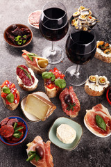 Appetizers table with italian antipasti snacks and wine in glasses. Brushetta or authentic traditional spanish tapas set, cheese variety