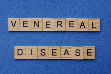 phrase venereal disease made from brown wooden letters lies on a blue table