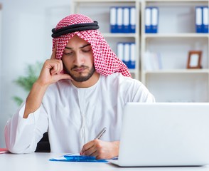 Arab businessman working in the office doing paperwork with a pi