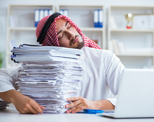 Arab businessman working in the office doing paperwork with a pi