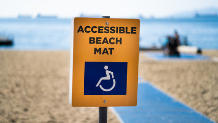 Accessible beach mat sign by the beach