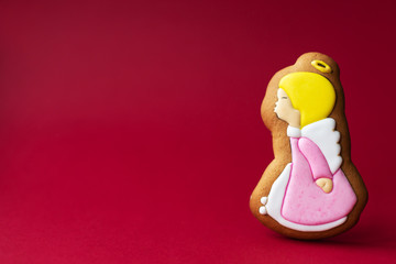 gingerbread cookie of little cute angels on red background. Traditional Christmas food. Christmas and New Year holiday concept.
