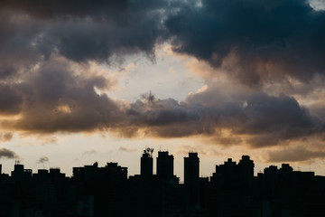 Fototapeta na wymiar silhouette of skyline with dramatic sky during sunset