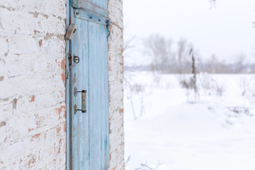 Shed with a blue wooden door. Winter