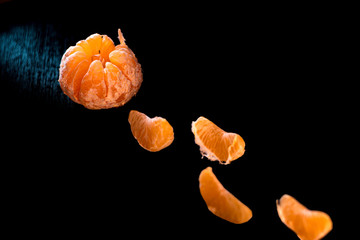 Composition with shelled Mandarin on black background. Fresh peeled mandarin orange on black...