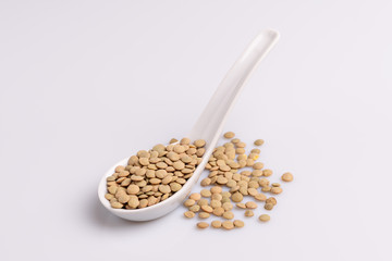 Dry uncooked lentils isolated on white background, copy space, studio shot, soft light. Christmas and New Year dish