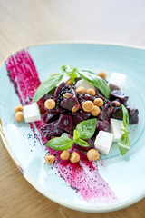 Healthy diet food. Italian salad with beetroot, basil leaves and cheese feta, with oil and small profiteroles.
