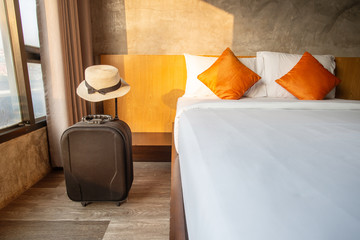 Fototapeta A suitcase with hat in comfortable hotel bedroom. obraz