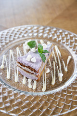 Blueberry sponge cake decorated with meringue and mint leaves. Breakfast in the cafe, morning coffee. on wooden table. Restaurant menu