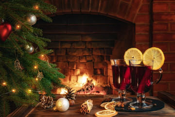 Christmas composition - two glasses with mulled wine on a wooden table near a Christmas tree...