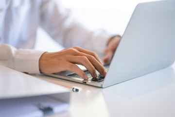 Close up of  businessman working on a laptop at the office. Man's hand typing on notebook computer.