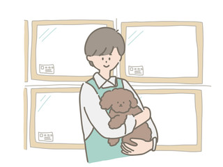 子犬を抱っこするペットショップの店員さん