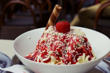 Close up on bowl of spaghetti ice cream with strawberry on top, or German ice cream dish...